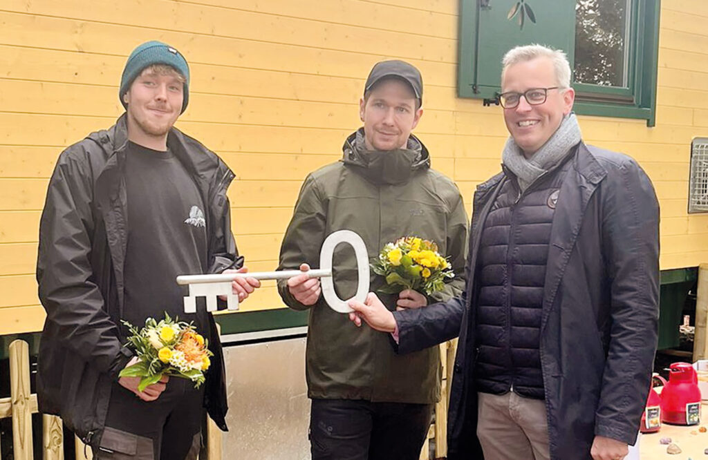 Symbolische Schlüsselübergabe durch Samtgemeindebürgermeister Knut Willenbockel an die beiden Waldpädagogen Andy Jahn und Lasse Abrat.